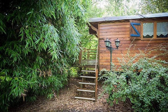 Entrée de la roulotte avec l'escalier en bois.