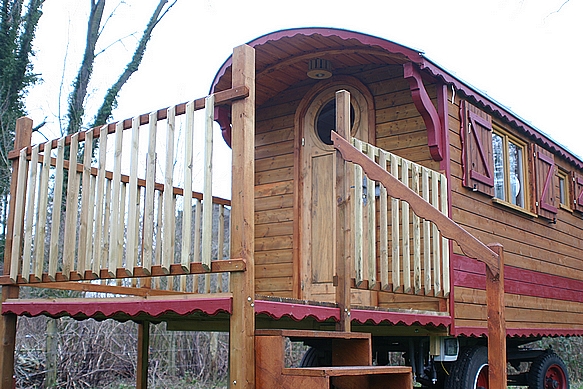 Roulotte avec sa grande terrasse sur le devant.
