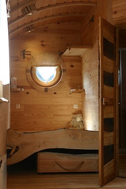 Lit alcove de la roulotte qui se situe près du lac Léman.