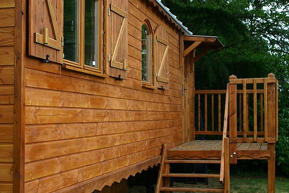 roulotte avec terrasse sur le côté et poêle à bois